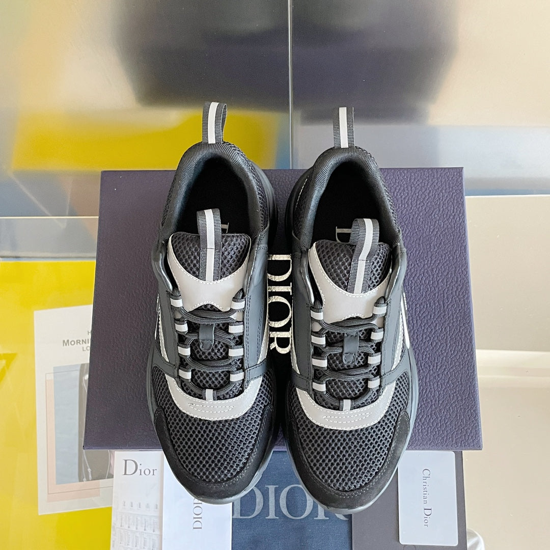 Two gray sneakers with black mesh and white accents, displayed on a purple box.