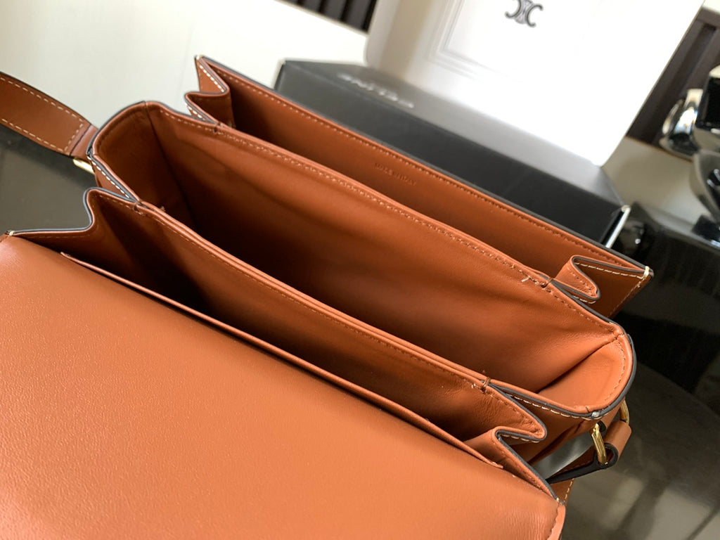 Celine bag open interior in orange leather with gold zipper pull and shoulder strap
