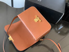 Celine bag in orange leather with gold-toned clasp and crossbody strap, open interior
