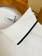 Close-up of white polo shirt collar with black trim and Burberry size tag