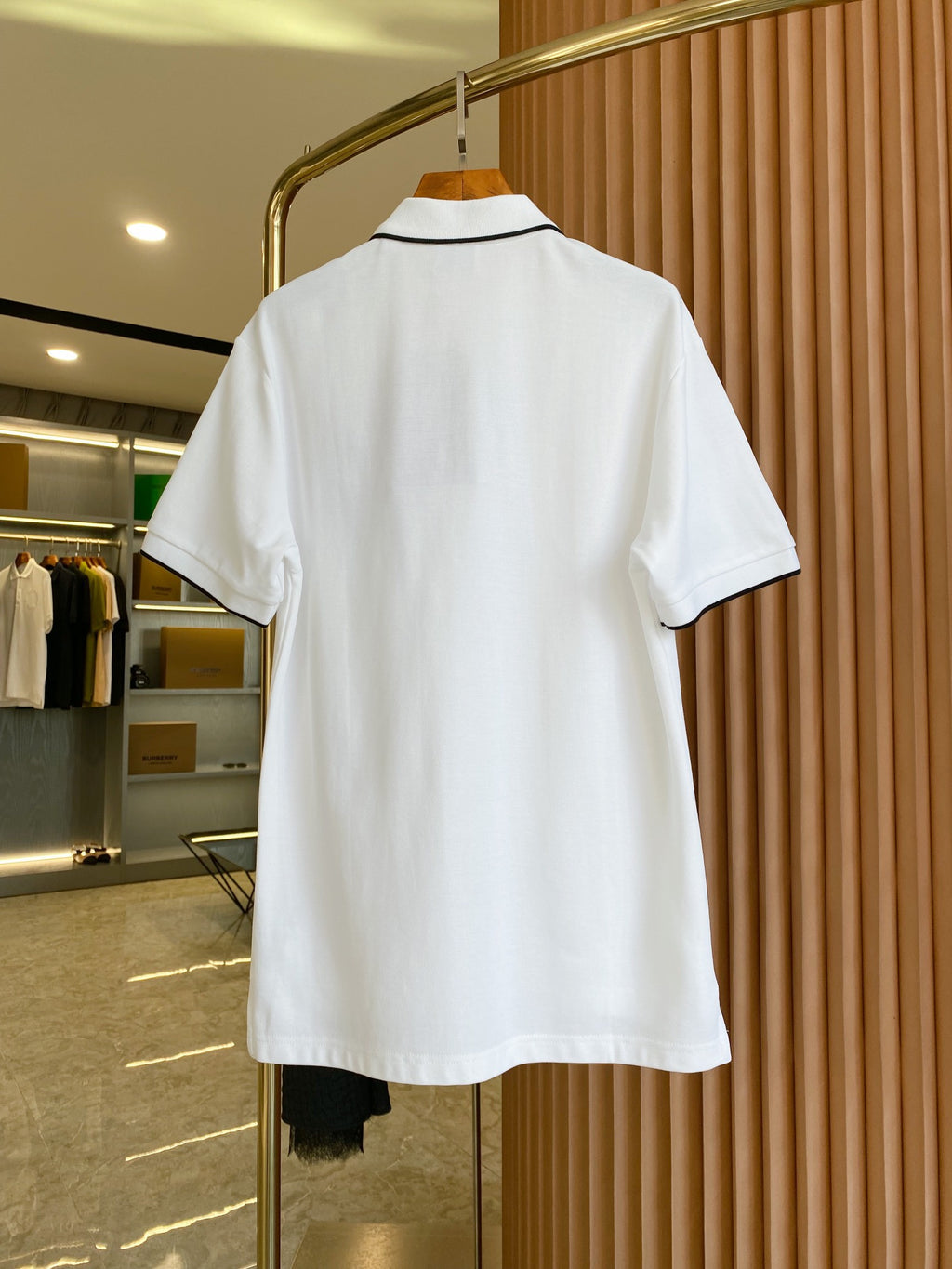 White polo shirt with black-trim collar, shown from the back