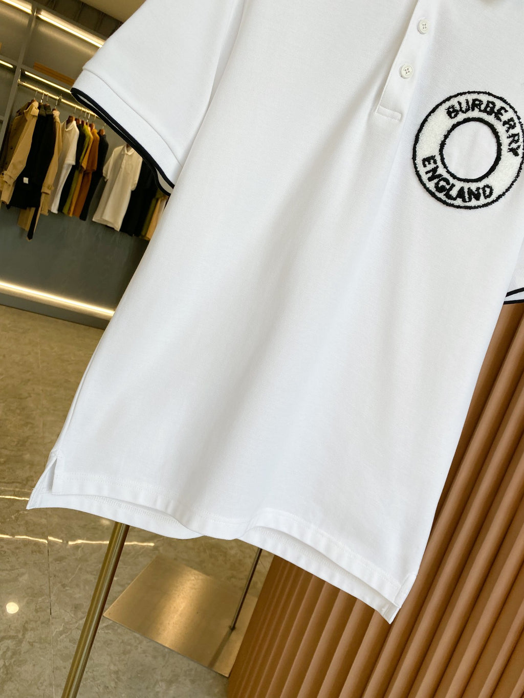 White polo shirt with black-trim sleeve edge and Burberry England logo patch
