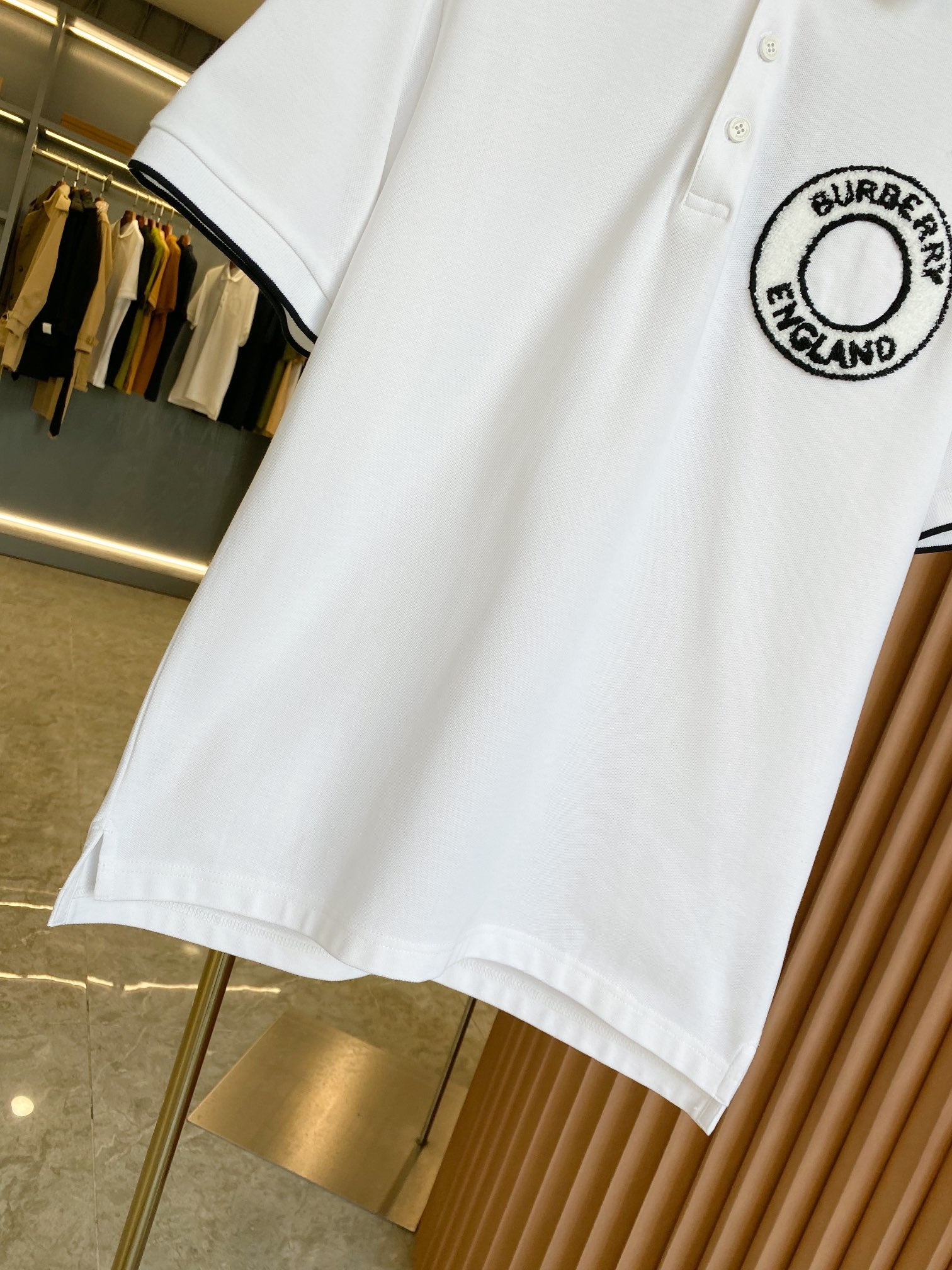 White polo shirt with black-trim sleeve edge and Burberry England logo patch