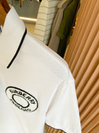 White polo shirt sleeve with Burberry England logo patch and black-trim cuff