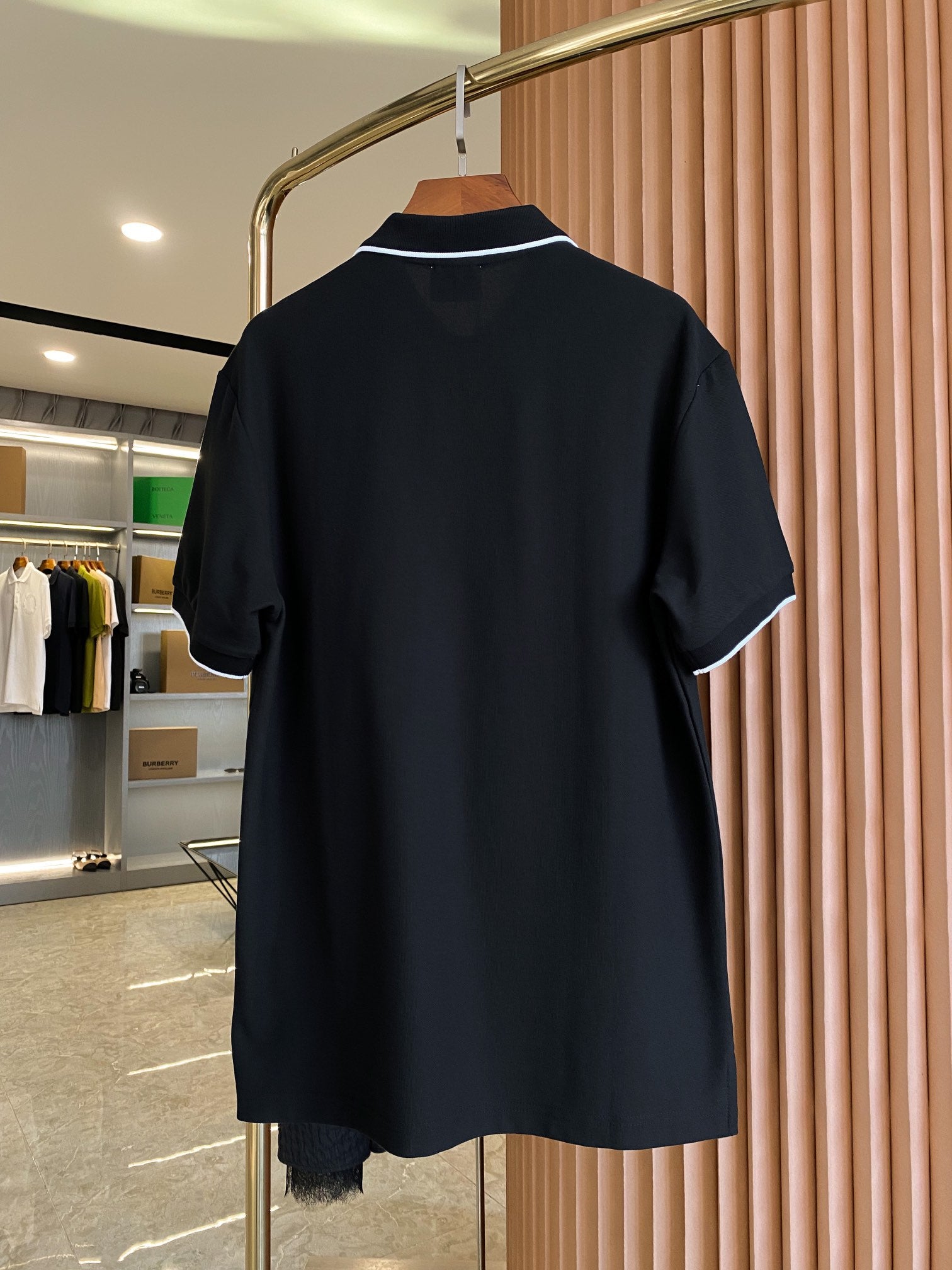 Black polo shirt back view with short sleeves and collar trim