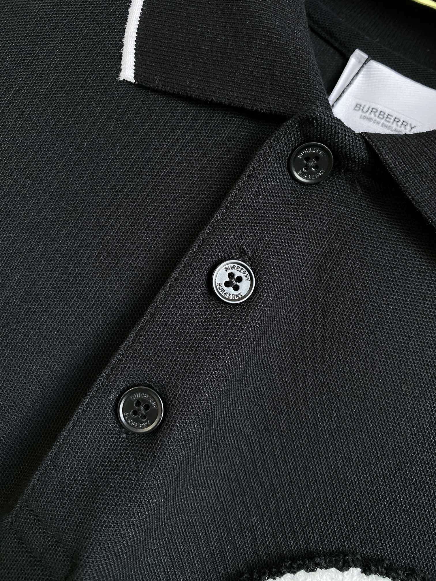 Black polo shirt placket detail with black buttons and white-trimmed edge