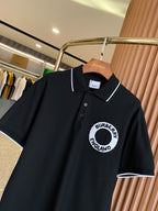 Black polo shirt front with short sleeves, white-trimmed collar, button placket, circular logo
