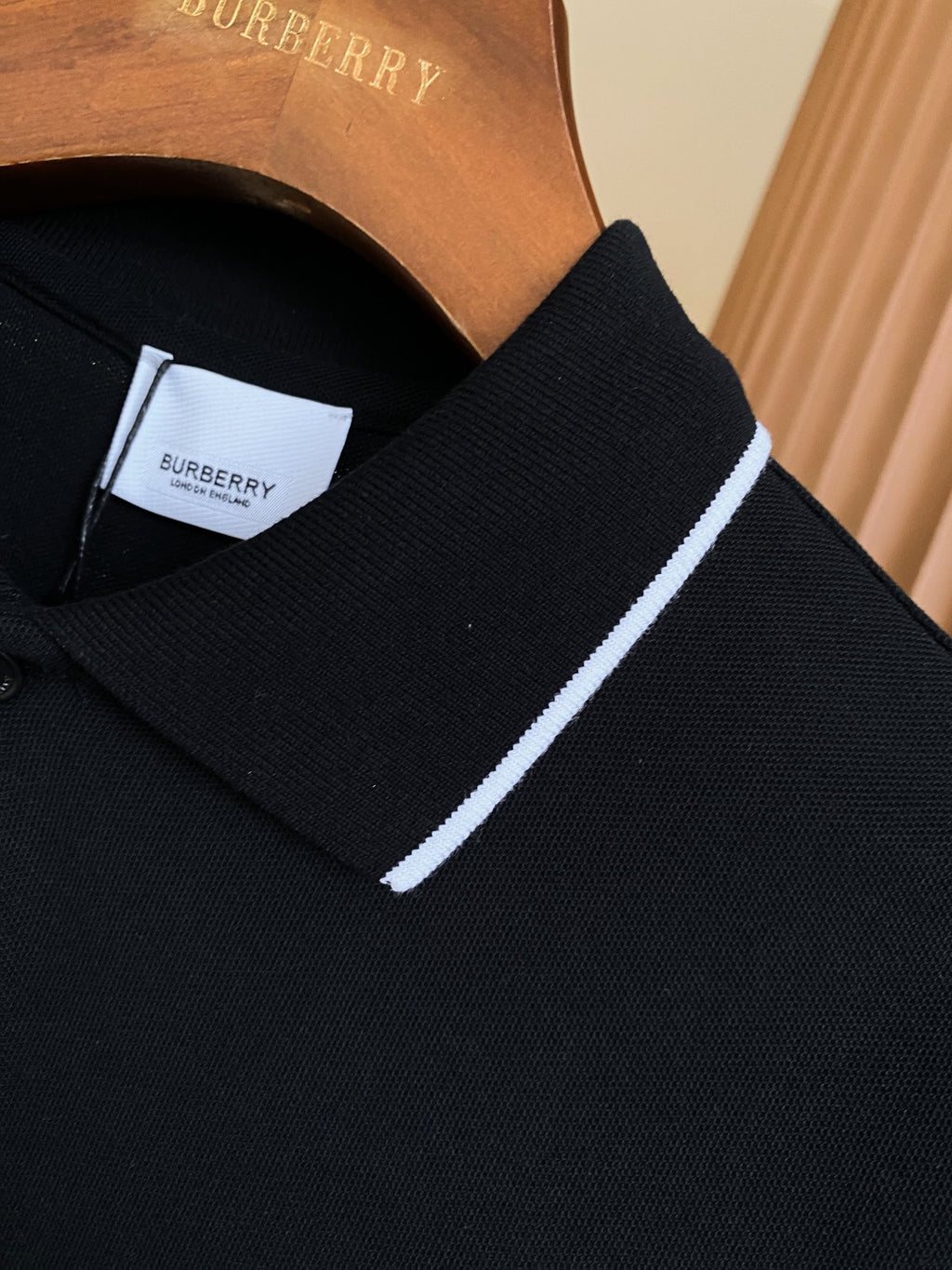 Black polo shirt collar detail with white trim and inside neck label