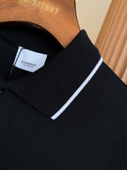 Black polo shirt collar detail with white trim and inside neck label