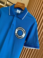 Blue polo shirt with white-trim collar and large Burberry England logo patch