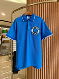 Blue polo shirt with white-trim collar and short sleeves, featuring a Burberry logo patch