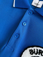 Blue polo shirt showing three button placket with blue buttons and white edge trim