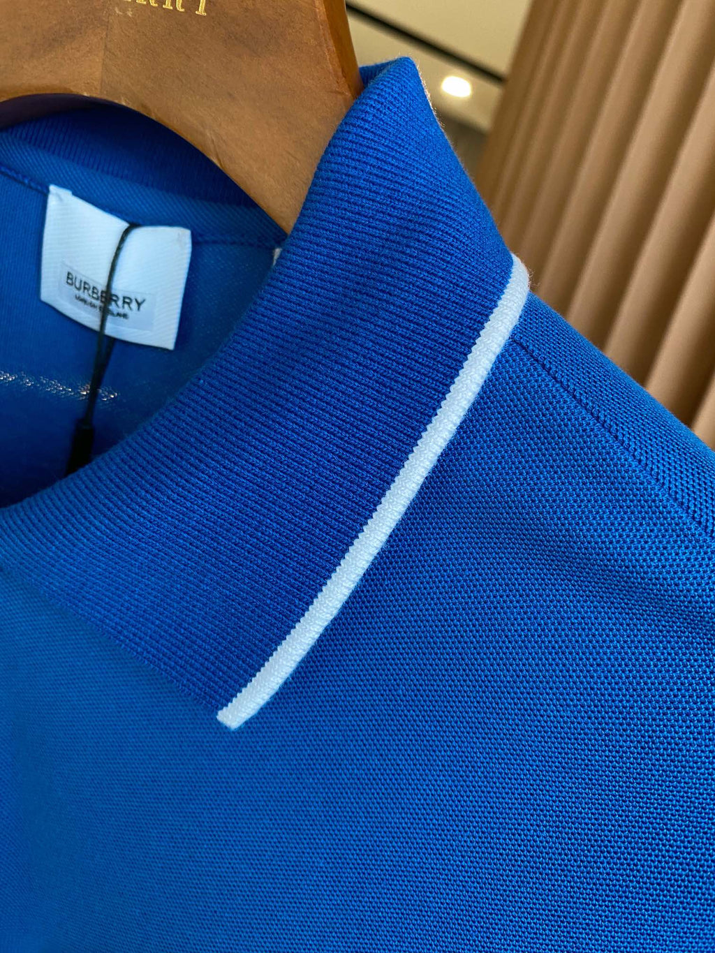 Blue polo shirt collar with white trim along the neckline