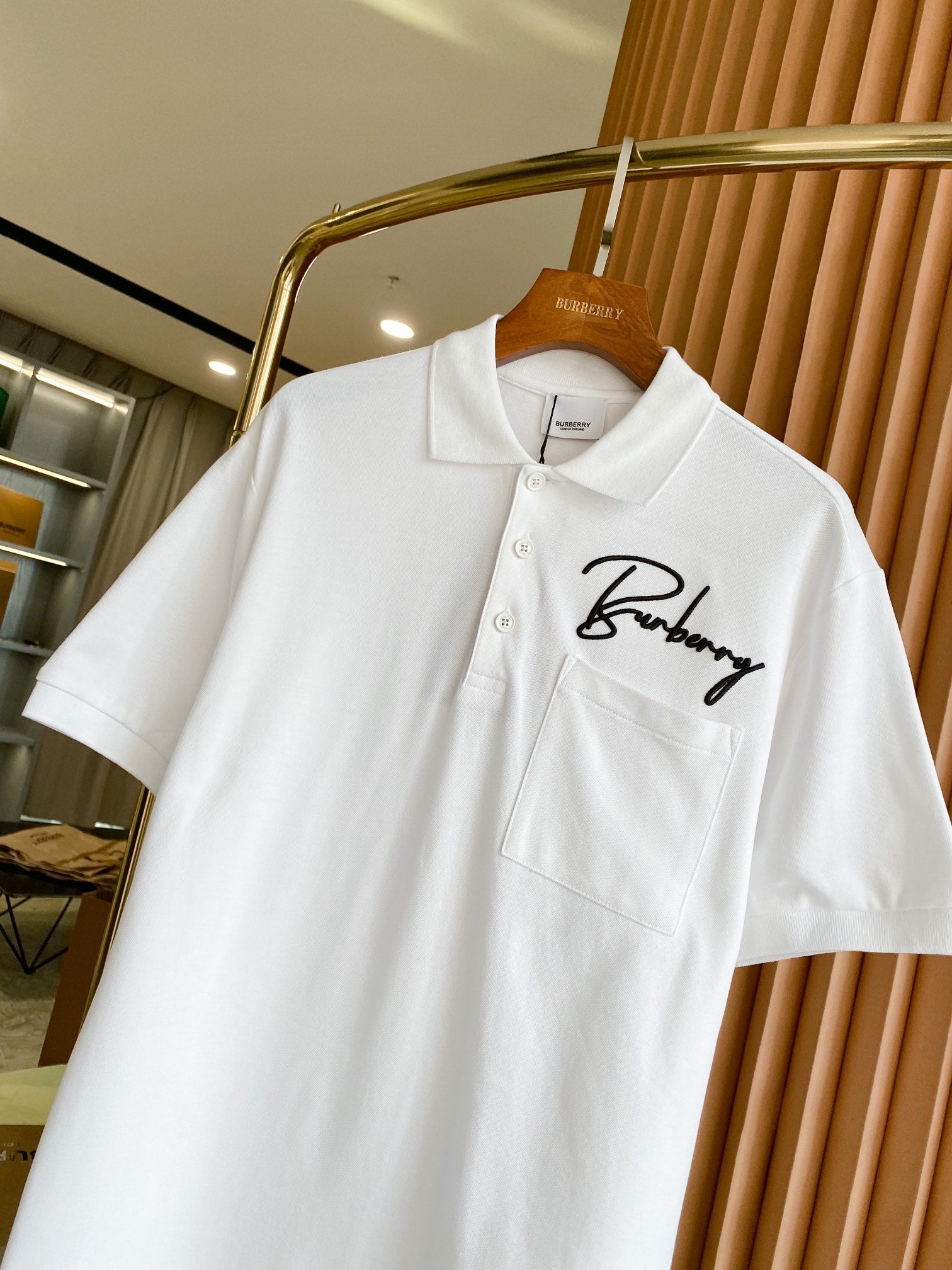 White Burberry polo shirt, front view with button placket and script logo