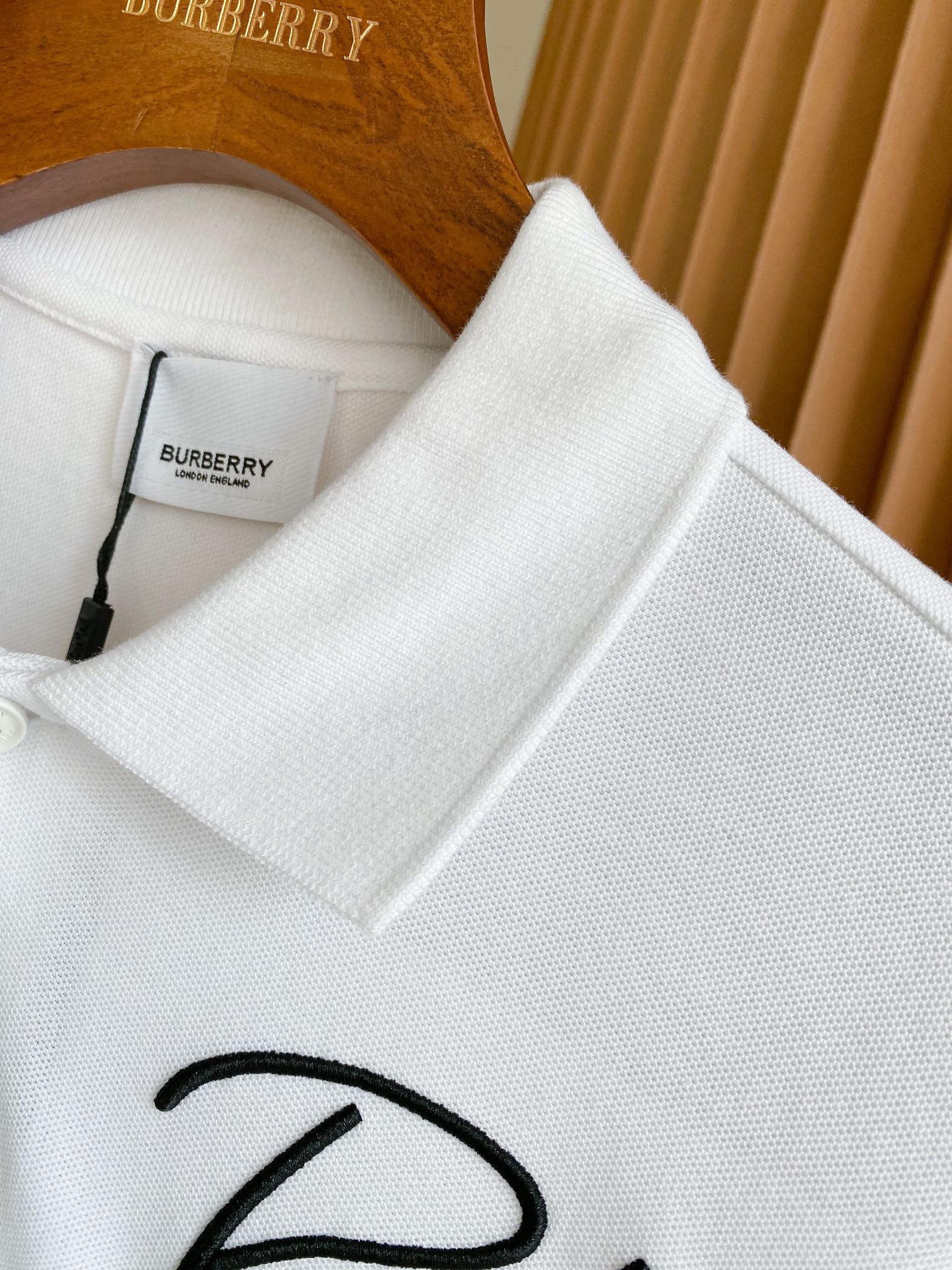 White Burberry polo shirt collar and buttons with size tag and embroidered logo