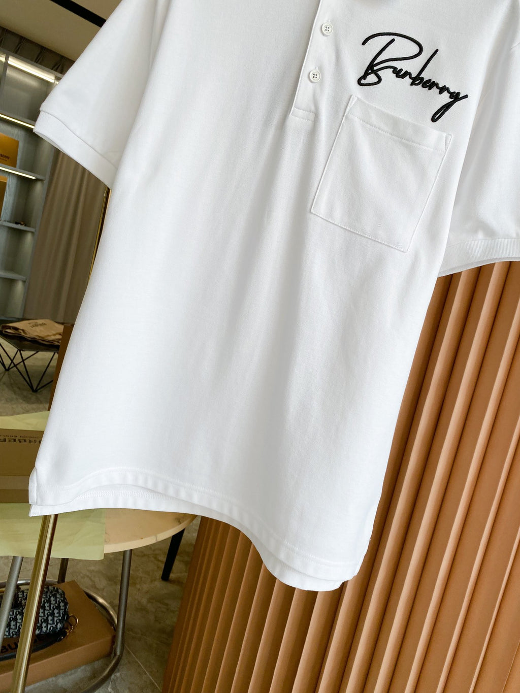 White Burberry polo shirt hem detail with front pocket and script logo
