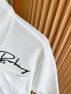 White polo shirt fabric with embroidered Burberry script on chest pocket