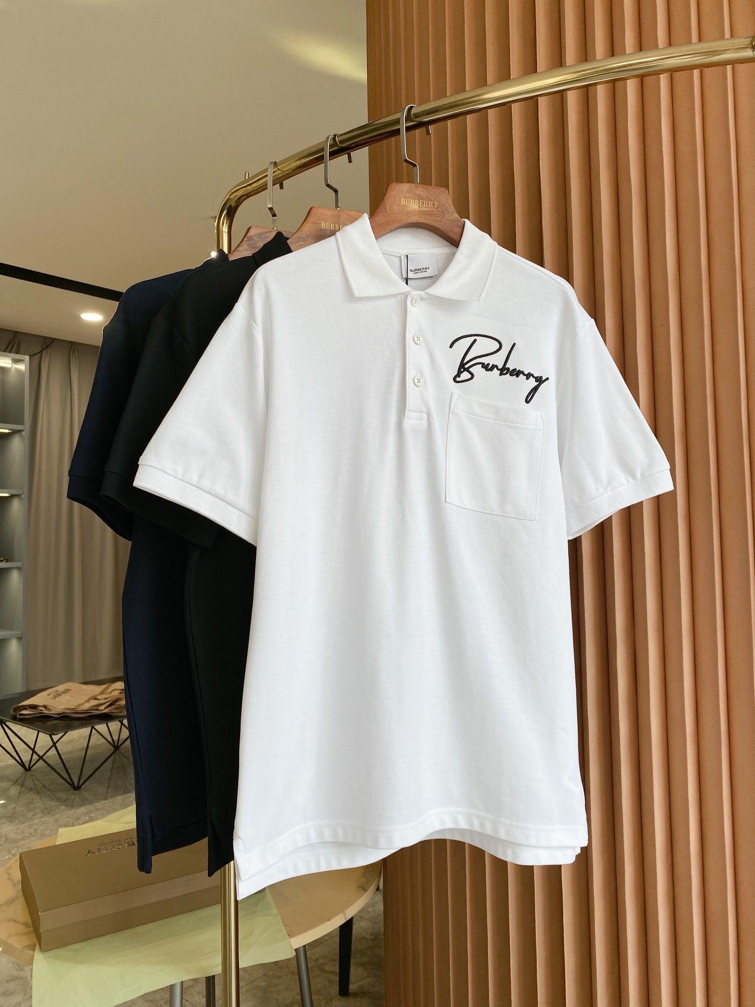 White Burberry polo shirt front view with chest pocket and script logo
