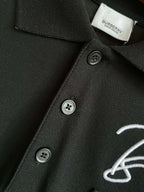 Black polo shirt collar and button placket with Burberry logo embroidery