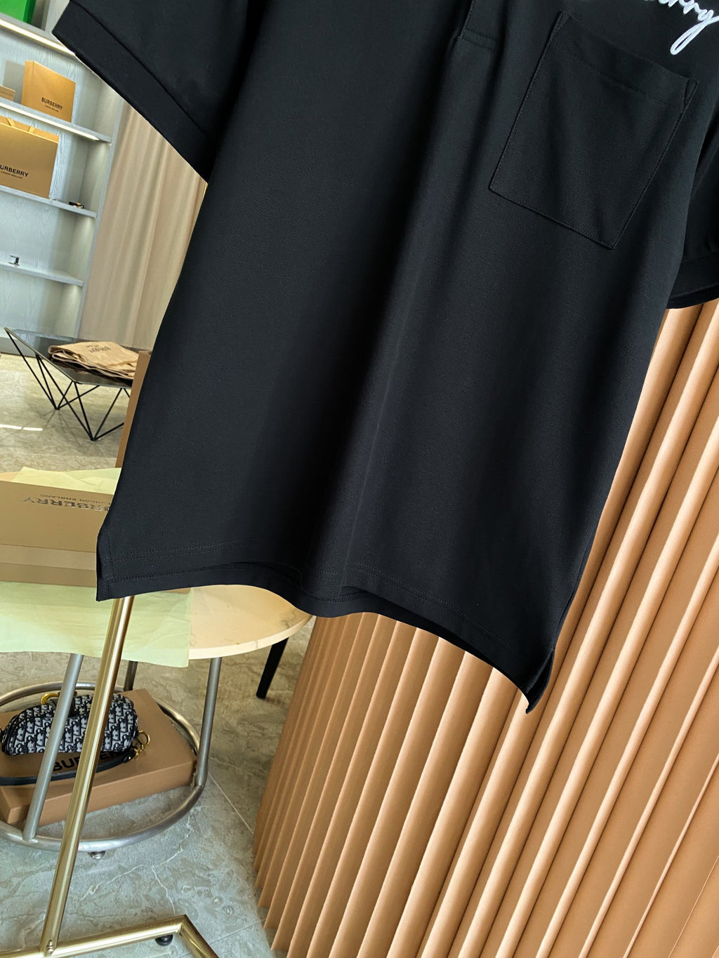 Black short-sleeve polo shirt hem with smooth fabric and side seam detail
