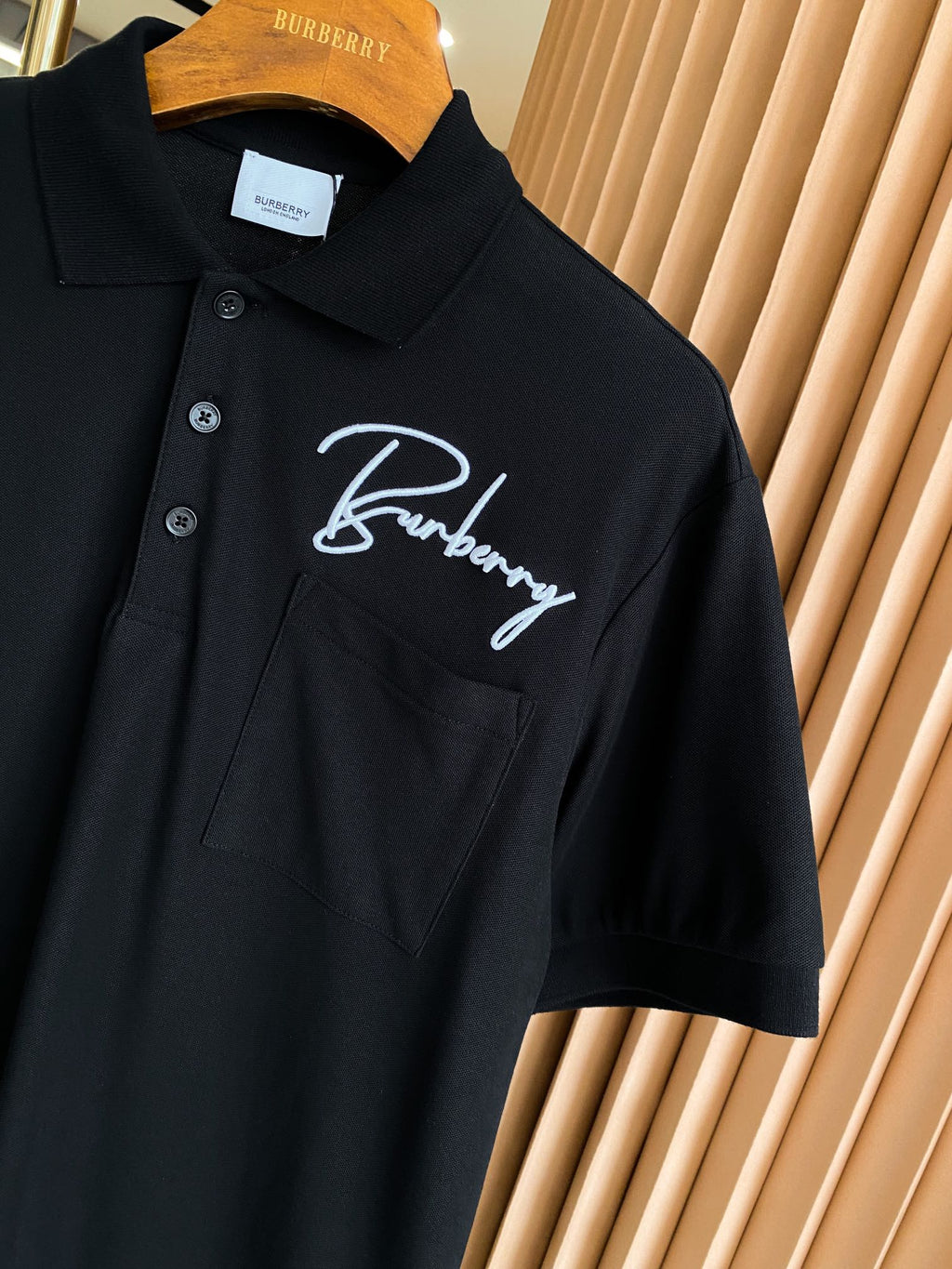 Burberry short-sleeve polo shirt in black with white script logo on chest