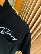 Black polo shirt shoulder with white Burberry logo embroidery