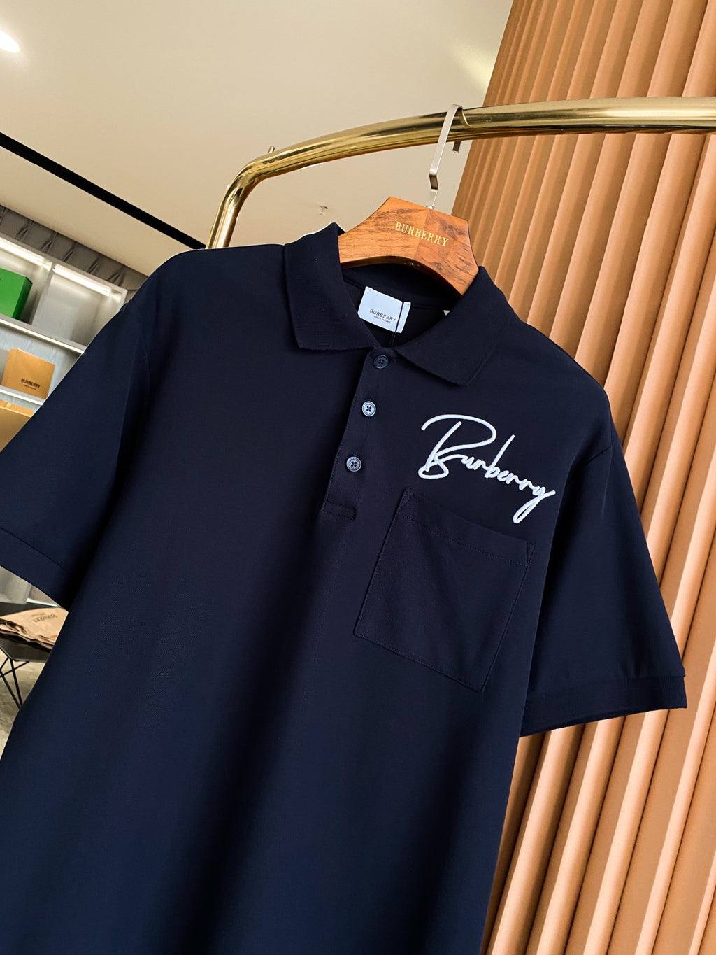 Burberry polo shirt in dark navy on hanger, collar with buttons, embroidered logo on chest