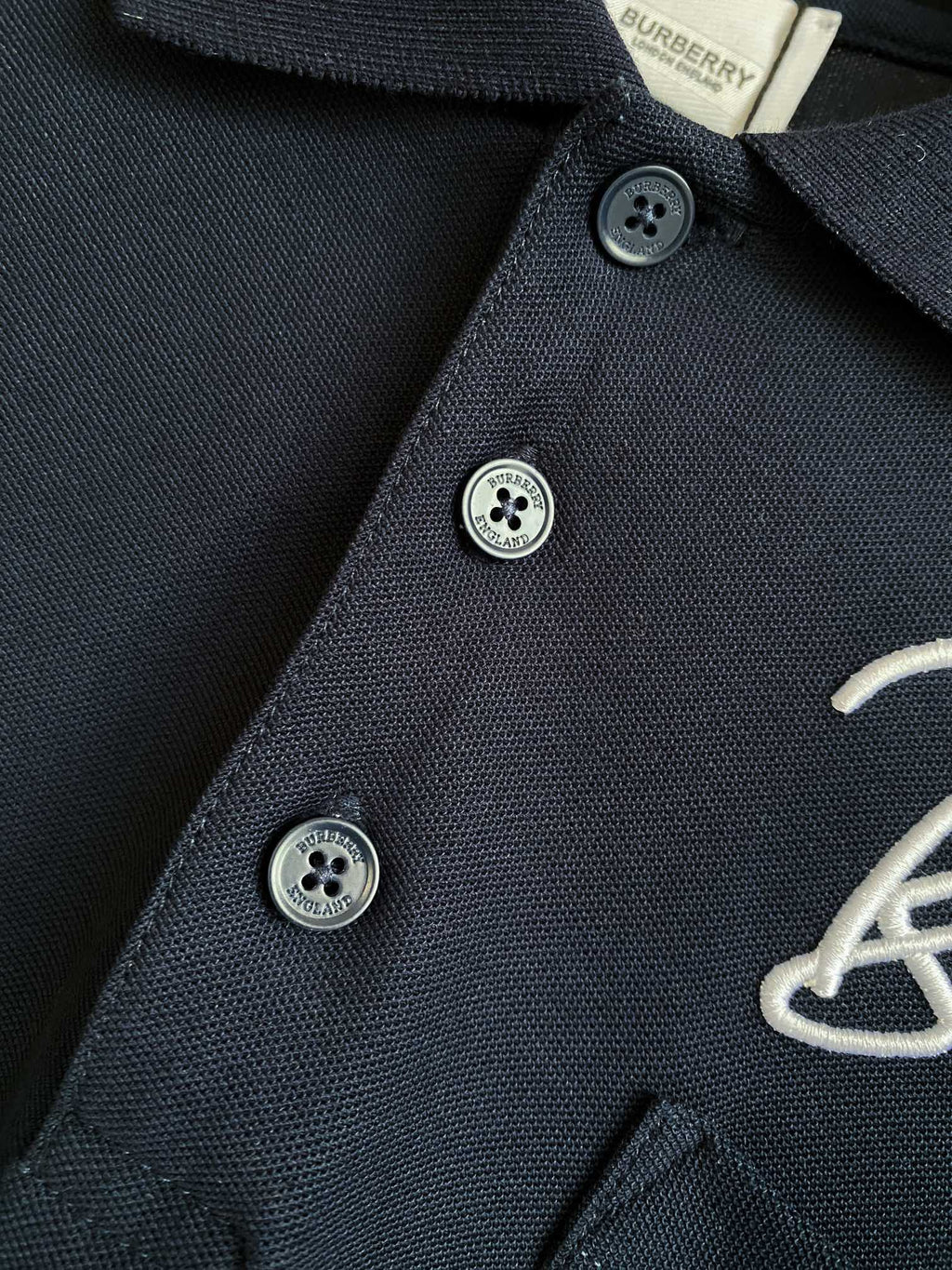 Burberry polo shirt dark navy close-up of button placket with three round logo buttons