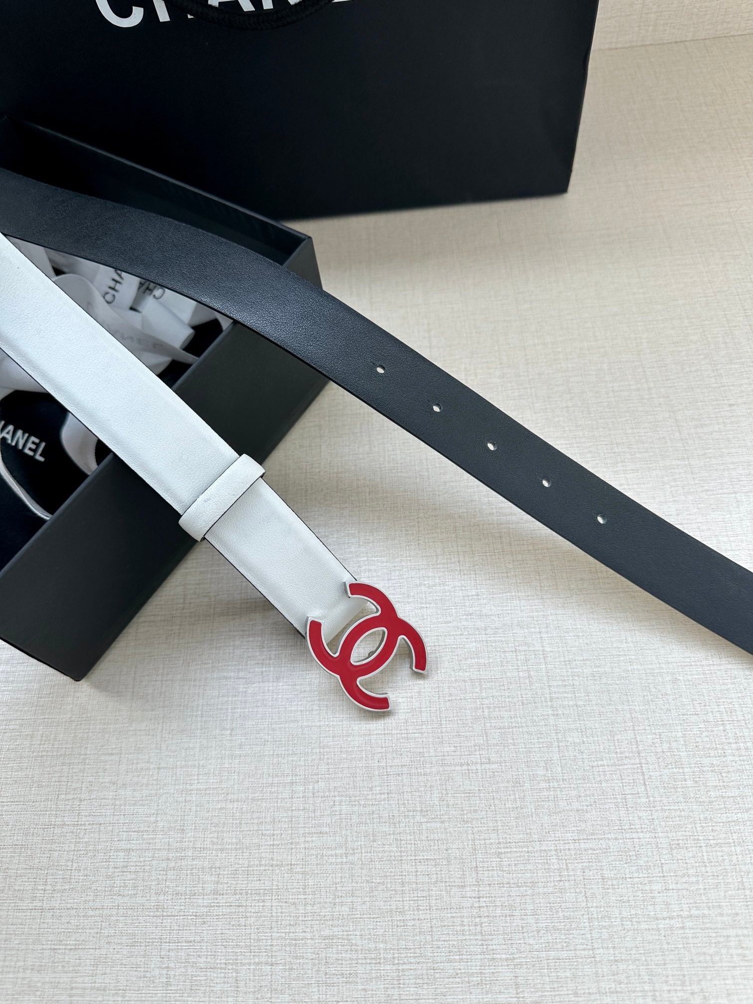 Leather belt pair with Chanel logo buckle, one light cream and one dark strap