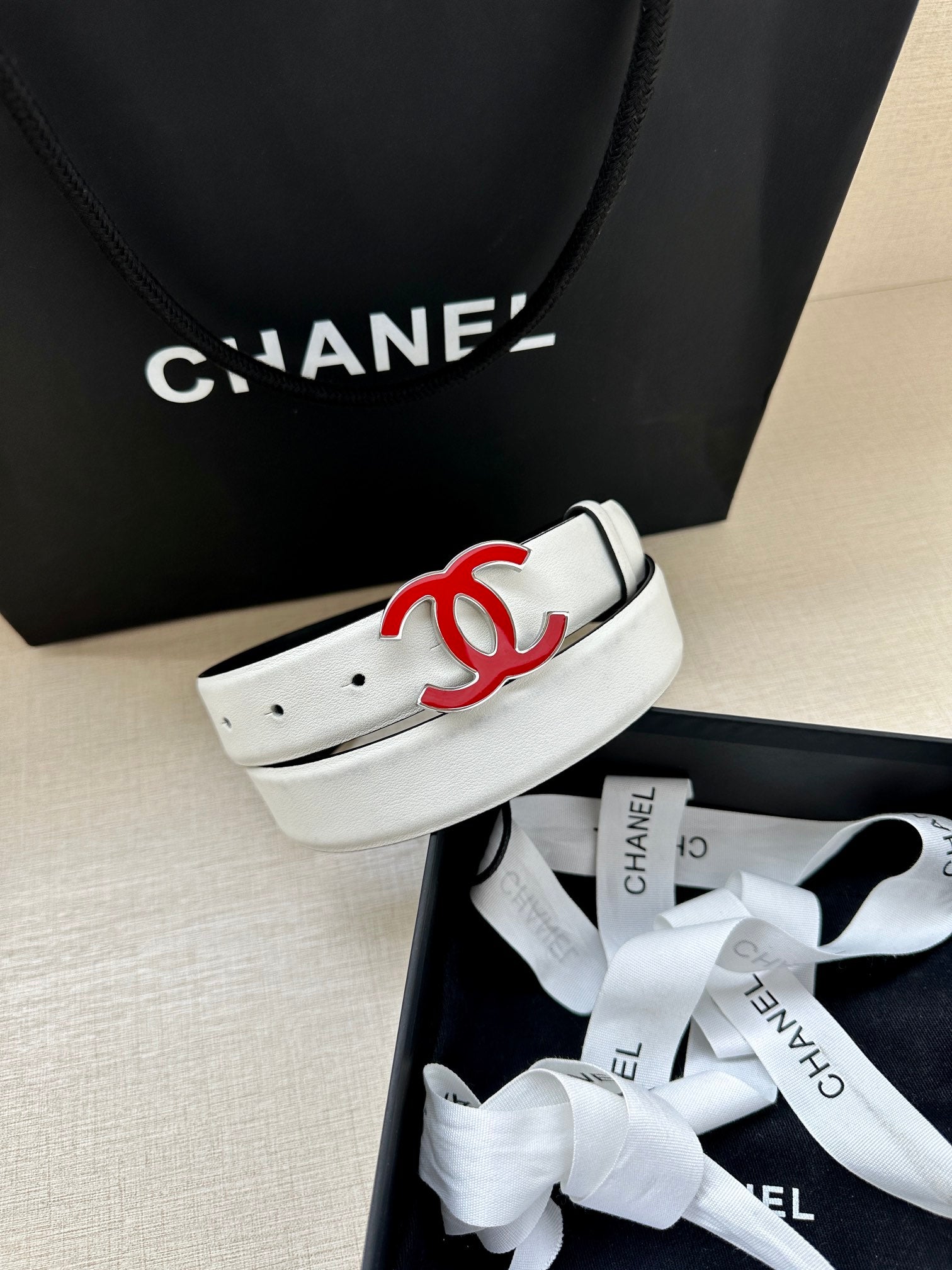 Leather belt with Chanel logo buckle, light cream strap and silver-tone holes