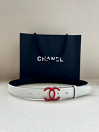 Leather belt with Chanel logo buckle, light cream strap laid flat with hardware holes