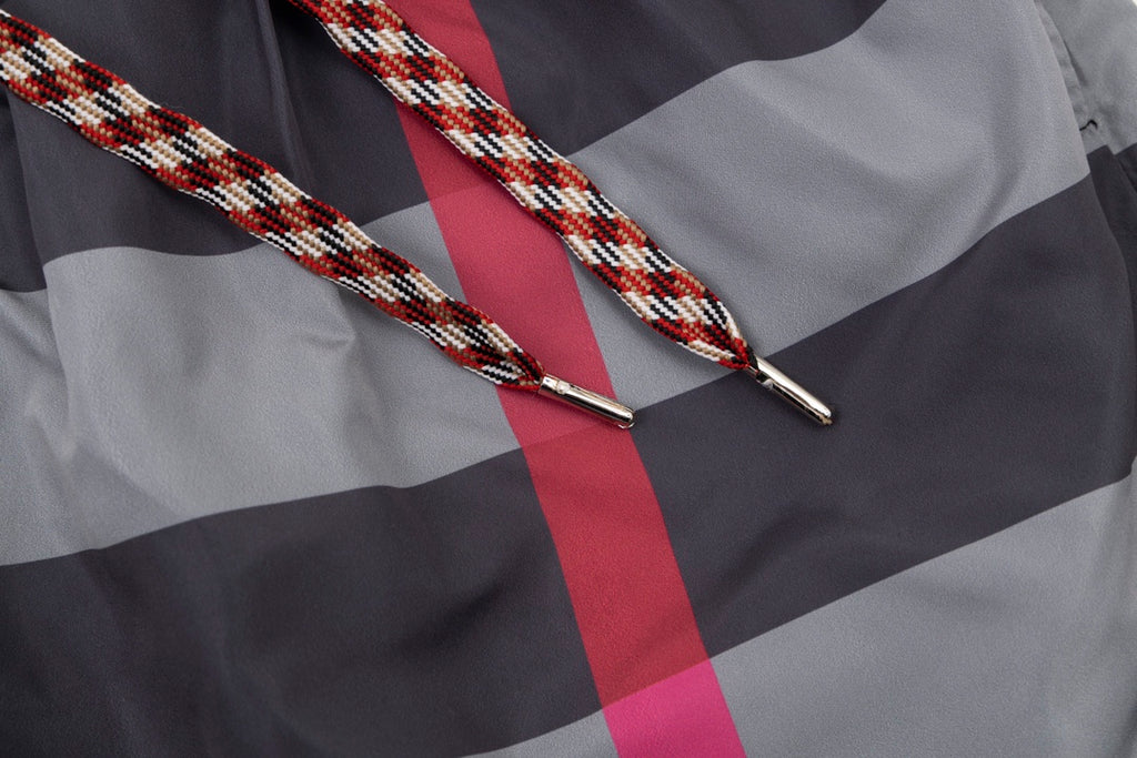 Braided drawstring ends with metal aglets on plaid pants, red and gray check
