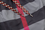 Braided drawstring ends with metal aglets on plaid pants, red and gray check