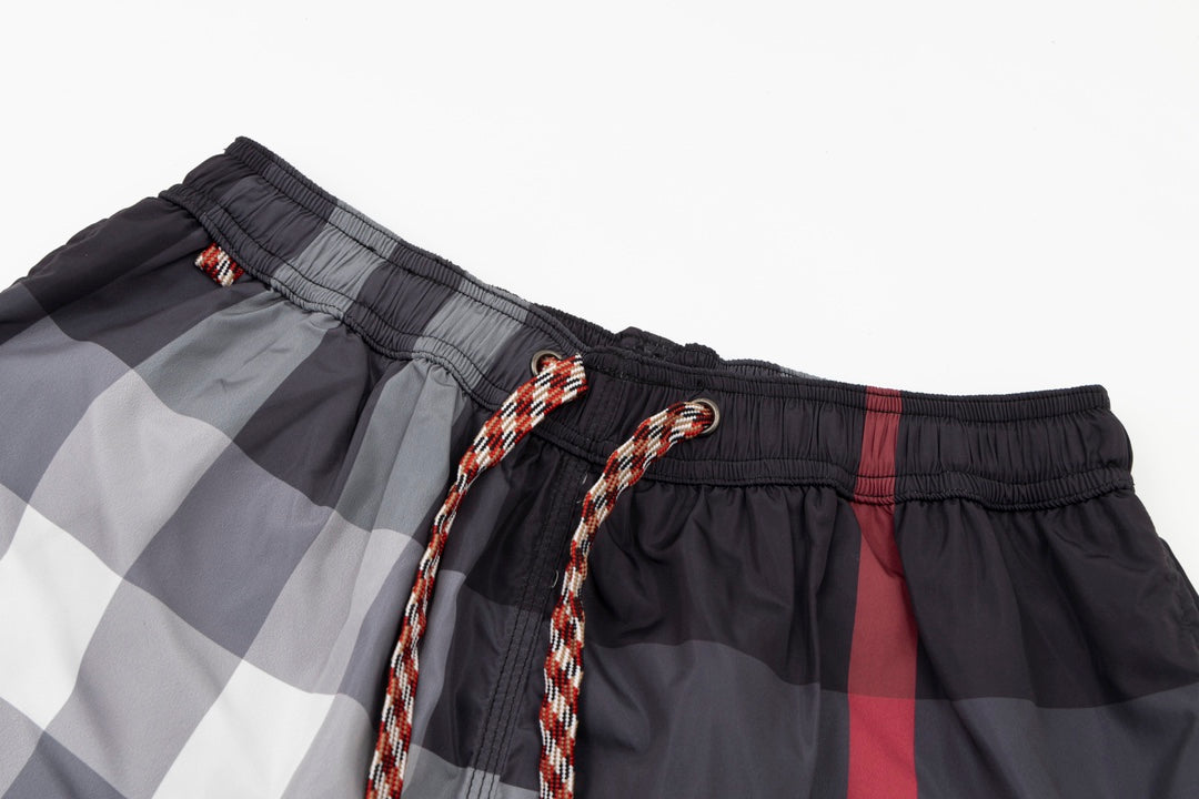 Plaid pants waistband detail with braided drawstring cords and black trim