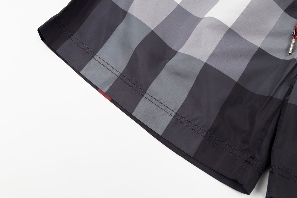 Plaid pants with curved hem and visible stitching, dark gray and light gray check