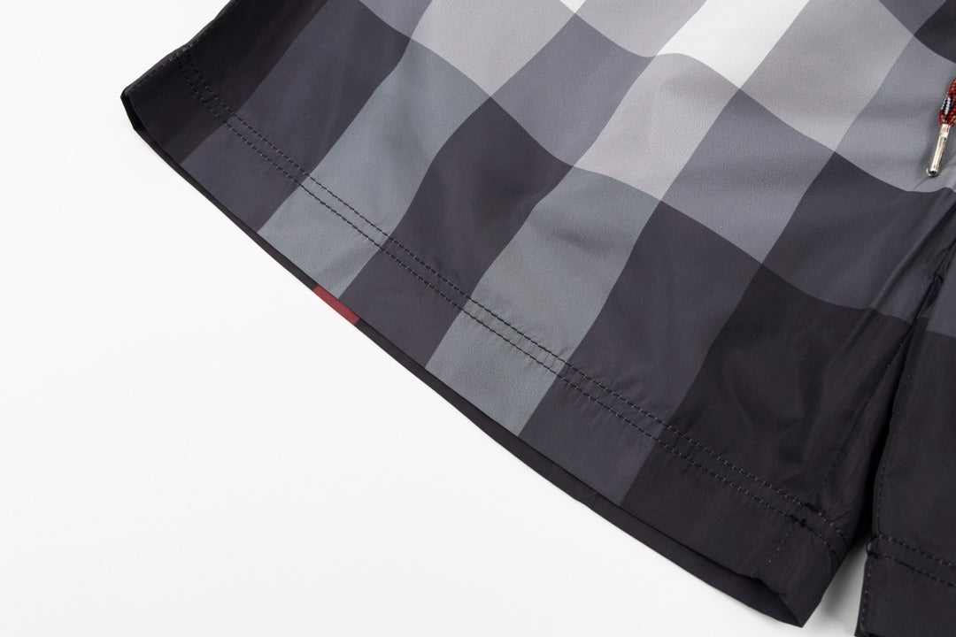 Plaid pants with curved hem and visible stitching, dark gray and light gray check