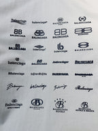 White T-shirt fabric with repeating black logo prints and signature-style marks