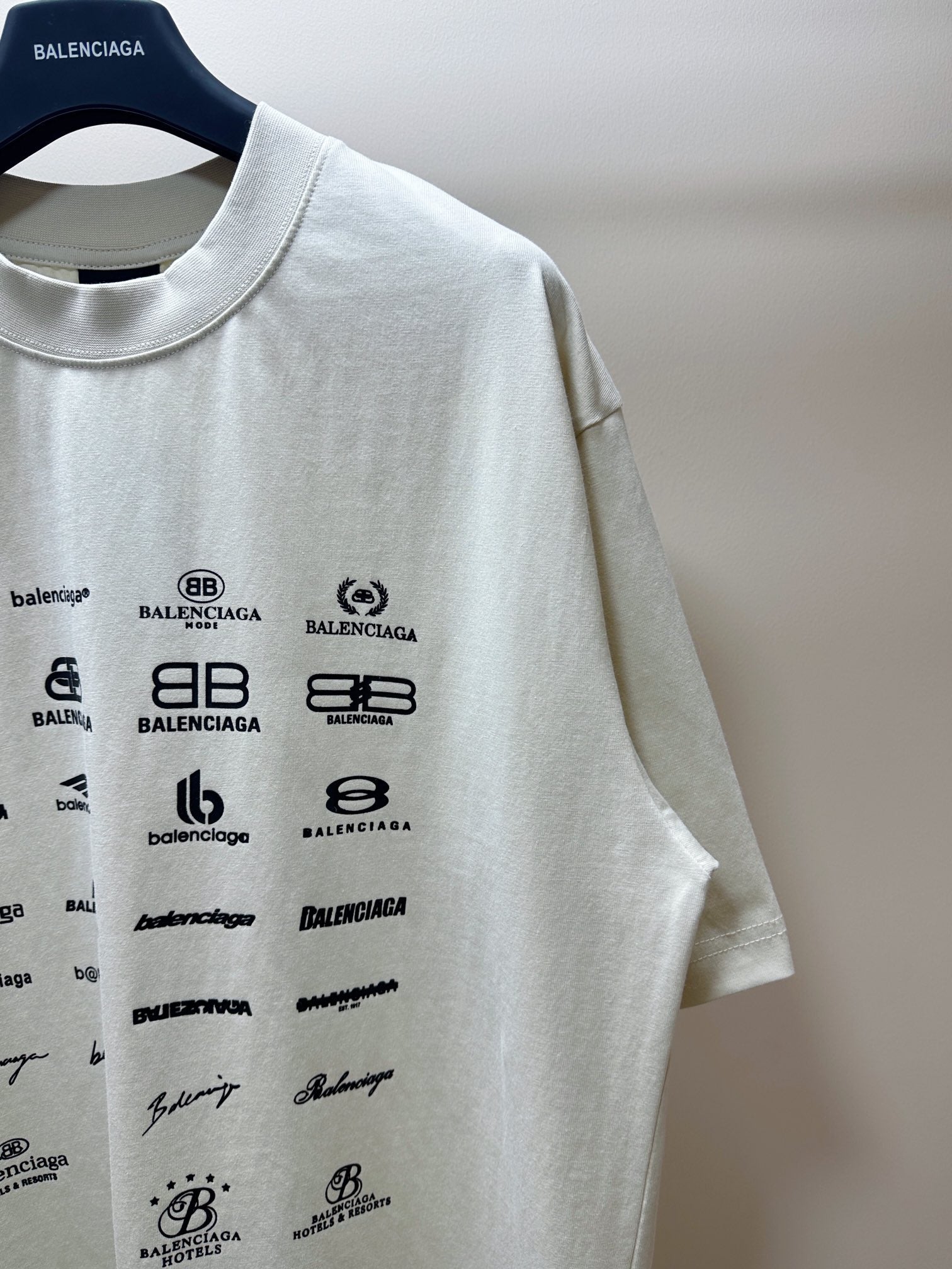 Balenciaga white T-shirt sleeve with black logo graphics near the shoulder
