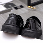 Versace patent loafers with textured platform heels and glossy black finish
