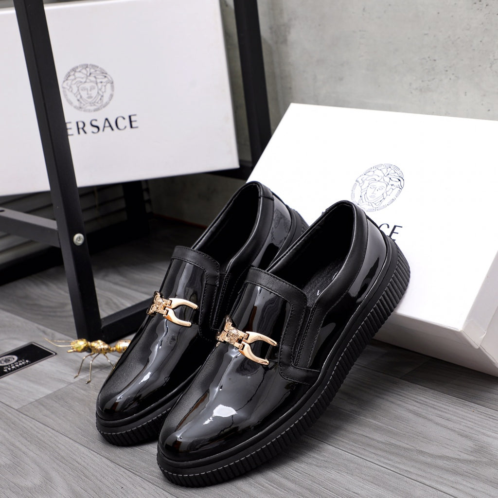 Versace luxury black patent loafers with gold buckle, pair front view