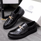 Versace luxury black patent loafers with gold buckle and textured rubber sole