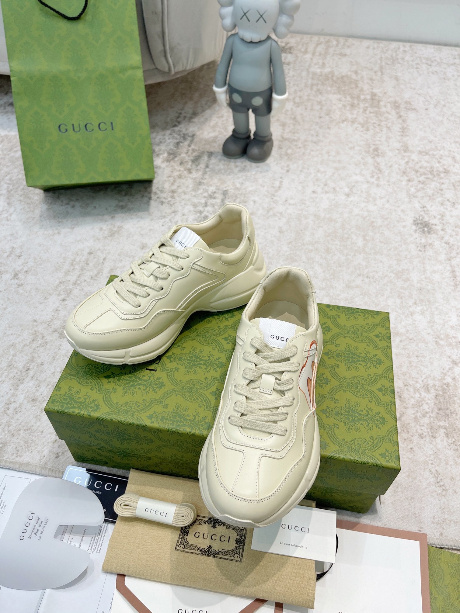 Gucci unisex cream sneakers, front close-up with laces and cartoon print