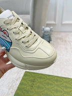 Gucci unisex cream sneaker close-up with blue character patch and lace-up