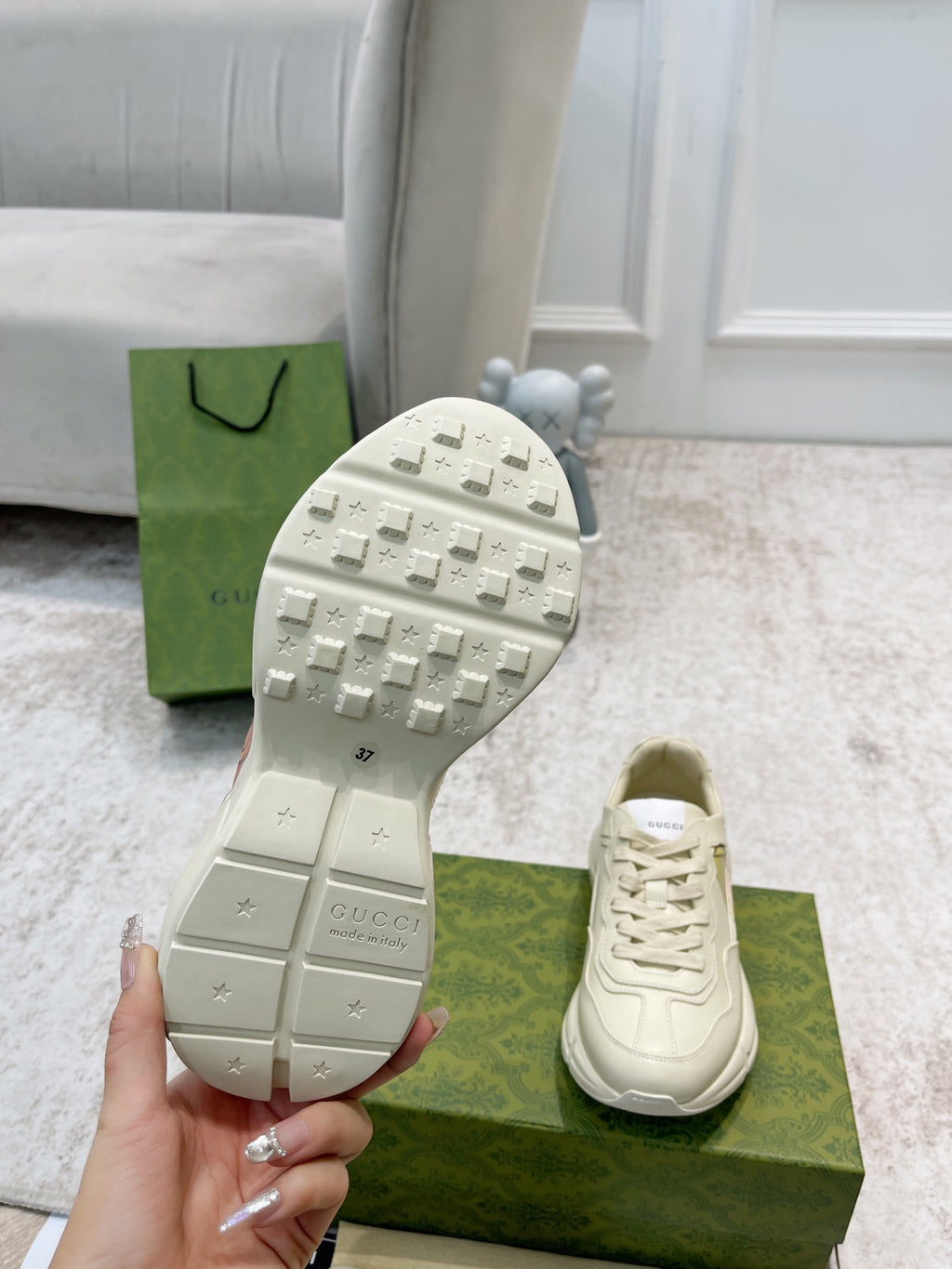 Gucci unisex sneaker outsole toe view with tread, with matching lace-up pair on box