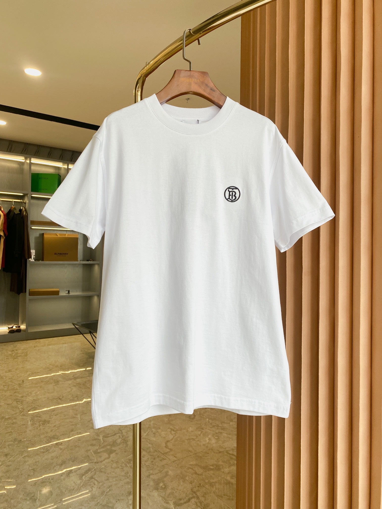 White short-sleeve crewneck T-shirt with small black chest logo on front.