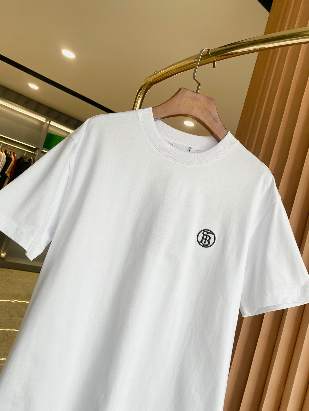 White crewneck T-shirt with short sleeves and small black chest logo detail.