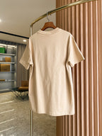 Light beige short-sleeve crewneck T-shirt front view on hanger with small chest logo