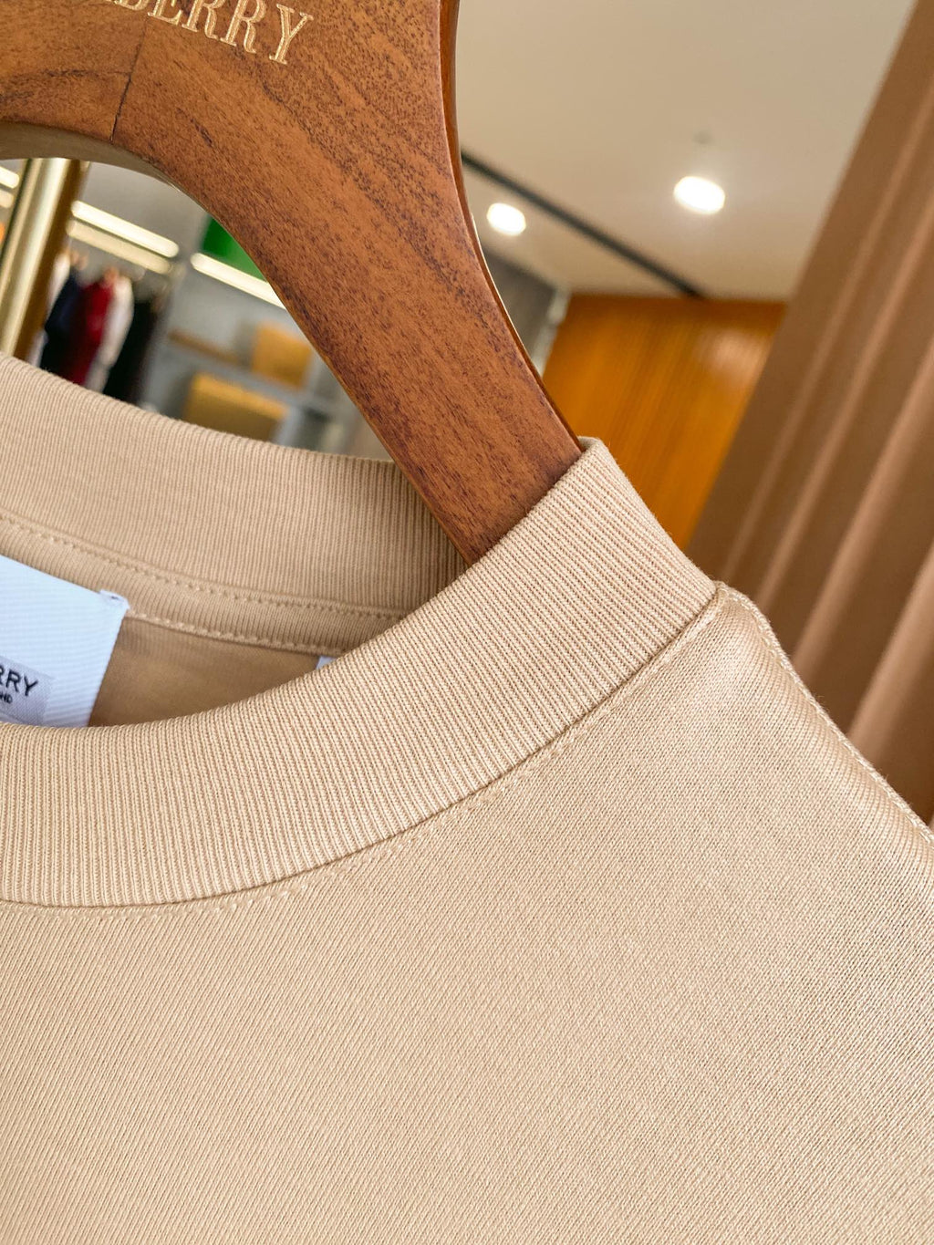 Light beige ribbed crewneck collar on short-sleeve T-shirt with logo patch