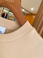 Light beige ribbed crewneck collar on short-sleeve T-shirt with logo patch