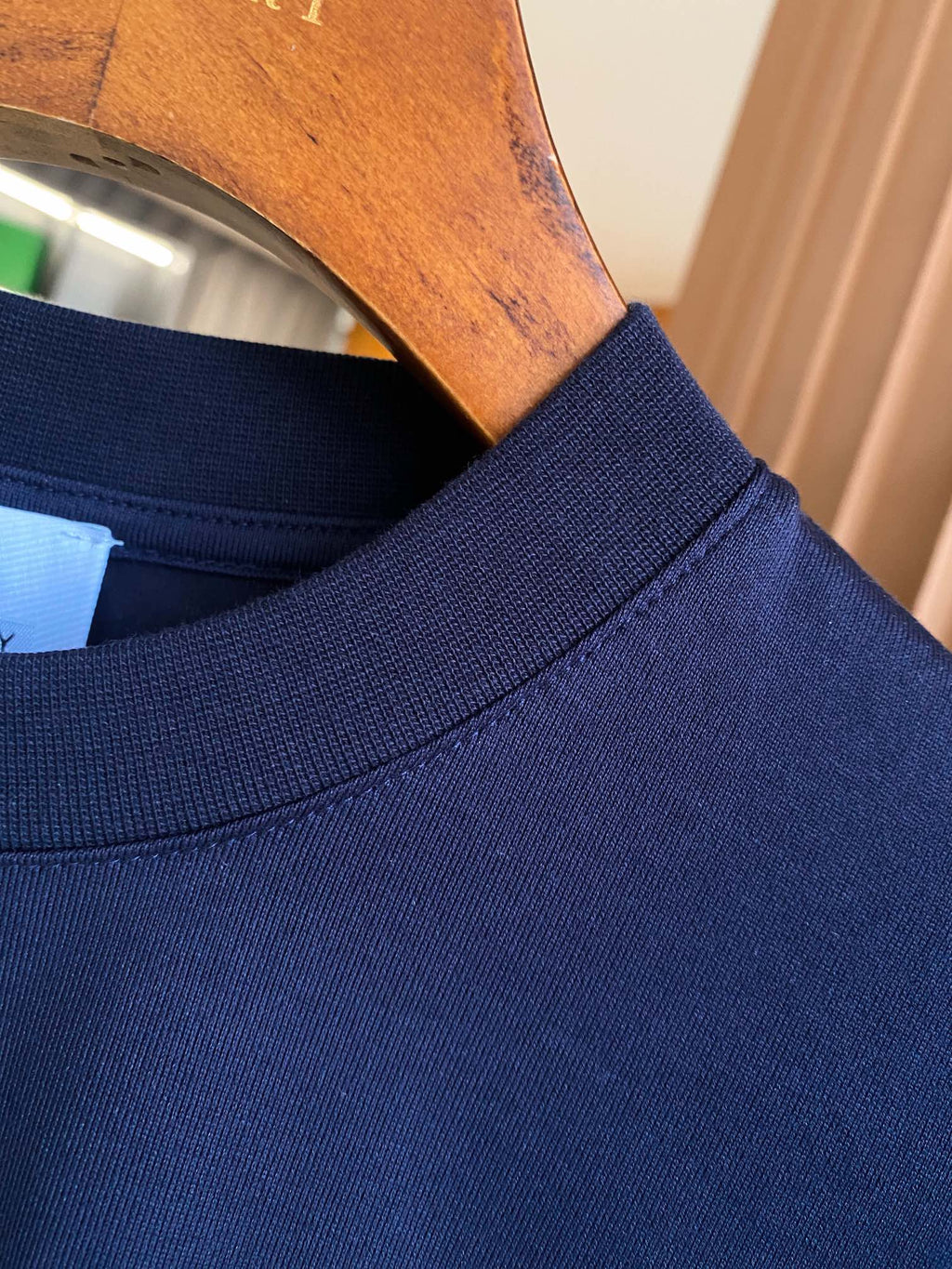 Navy crew-neck T-shirt neckline and collar seam detail.